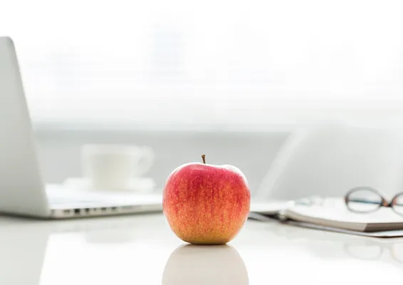 机の上にリンゴが置いてある写真。