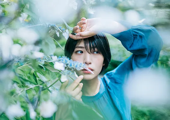 切り抜きツールでキャンバスを横に広げ、「生成拡張」を実行。人物の隣に、元の背景と調和した風景が自動で生成され、バナー広告などに使いやすい横長の画像になっている。